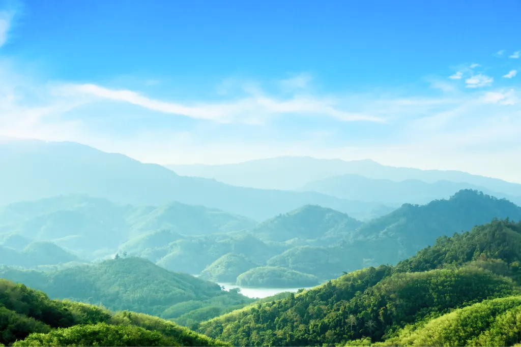 青空の下に連なる霞んだ緑の山並み